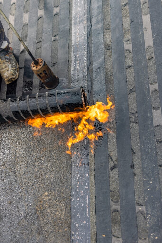 Bituminous membrane waterproofing system details and installation on flat rooftop.